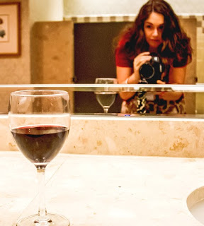 Image of woman taking a photo of a wineglass Image of woman taking a photo of a wineglass